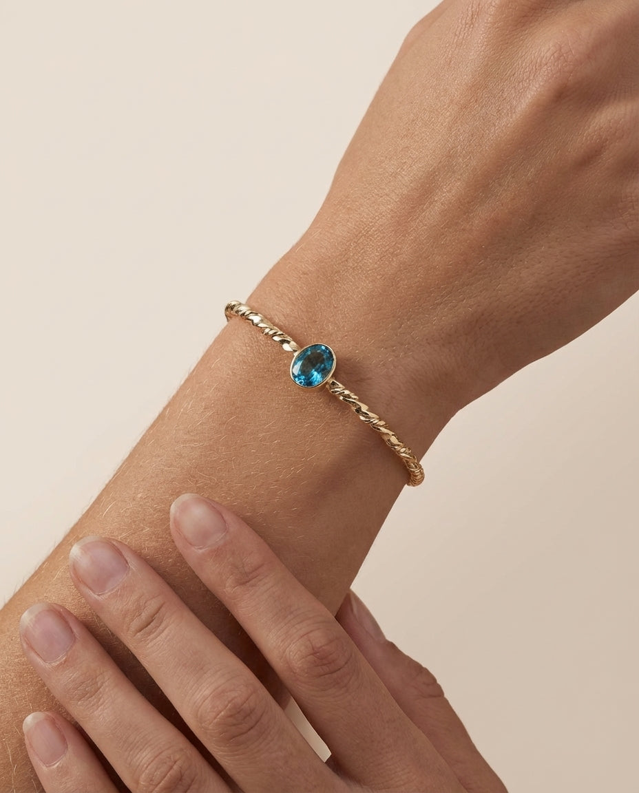 Twisted Gold Bangle with Oval Blue Topaz