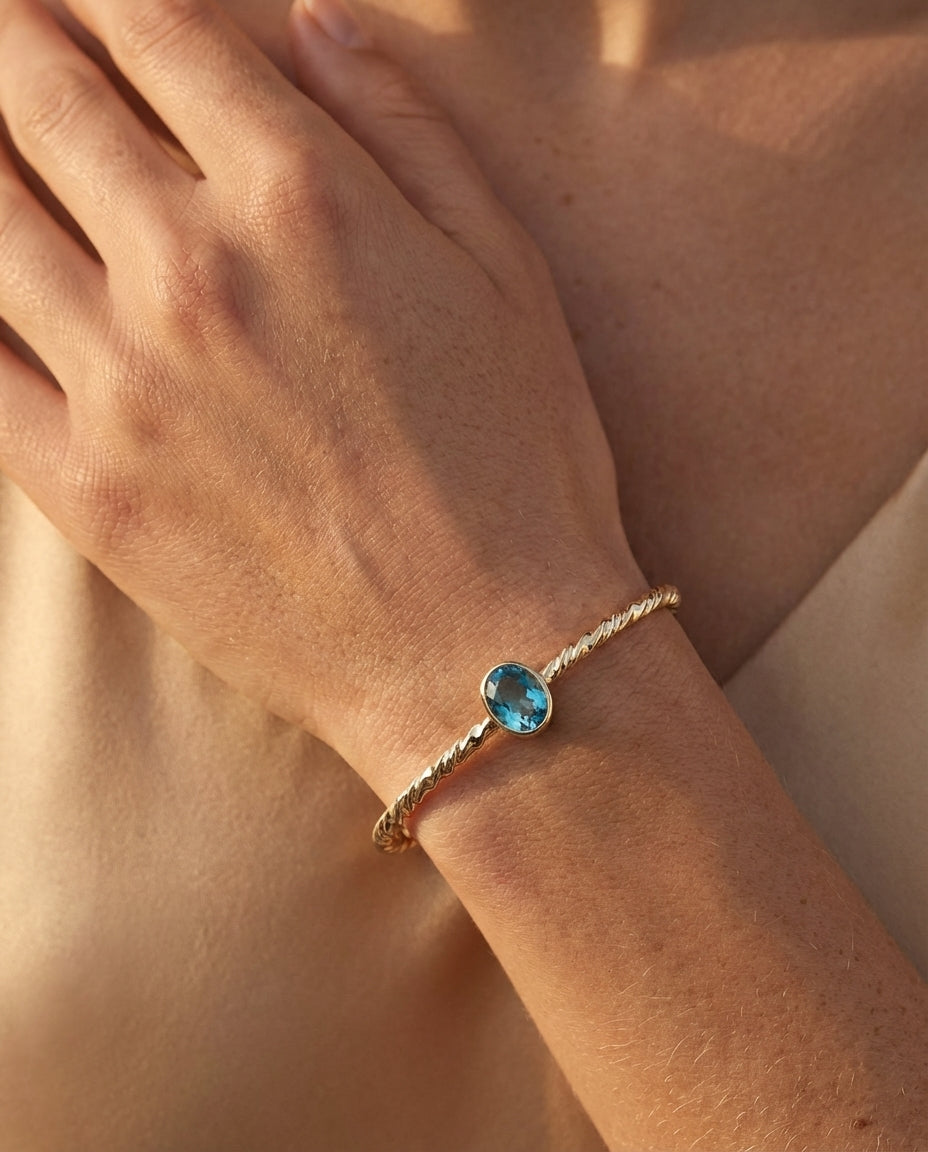 Twisted Gold Bangle with Oval Blue Topaz
